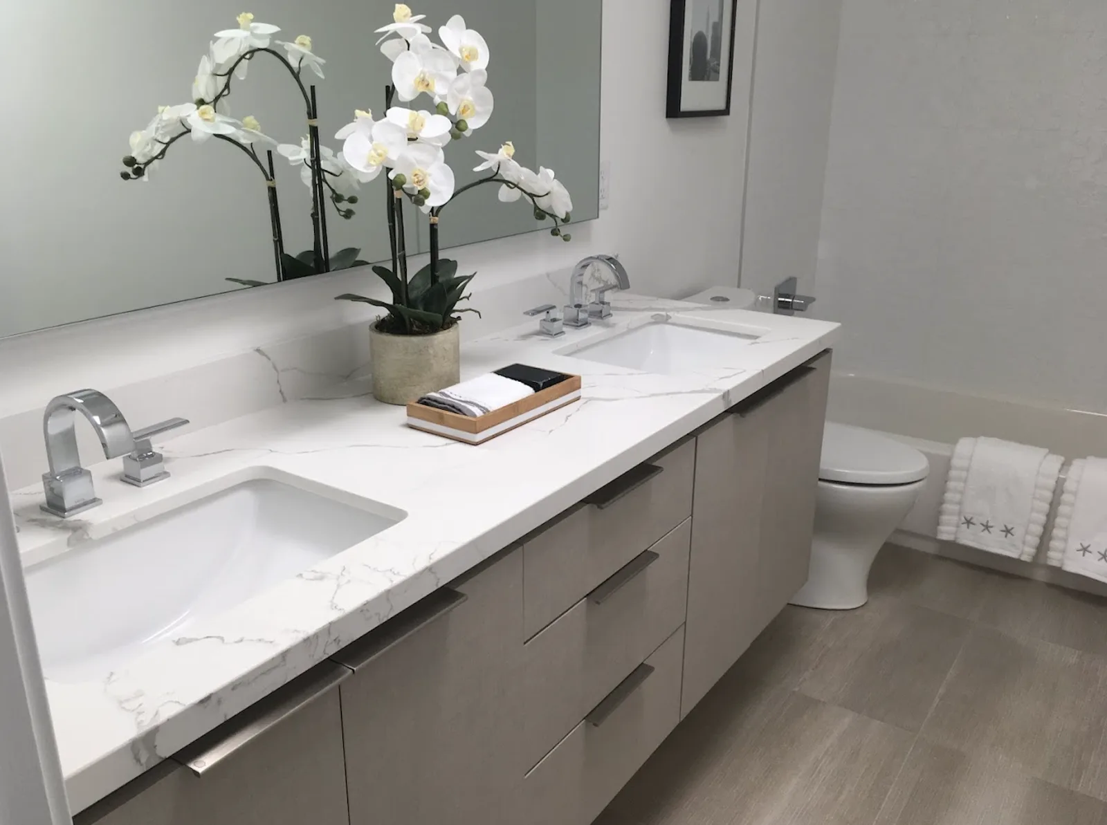 Bathroom double vanity with marble-look countertop, two undermount sinks, chrome faucets and gray flat-panel drawers